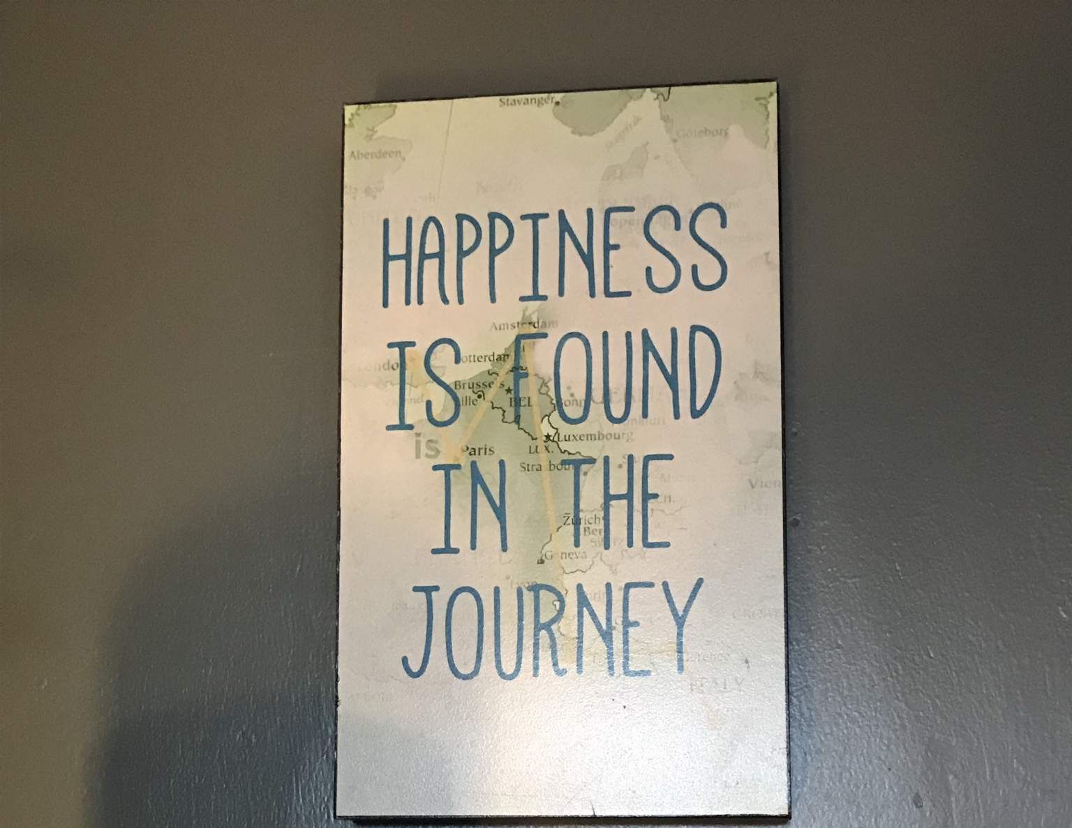 Wall sign reading Happiness is found in the journey